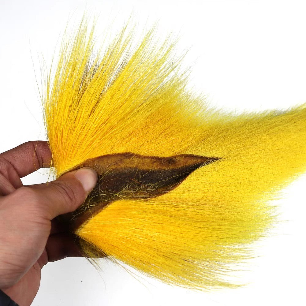 WBQ Tackle supplies bright yellow bucktail fur for fly tying, with a natural brown hide base.